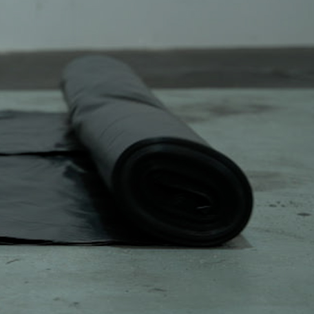 Roll of 1000 gauge polythene membrane part-unrolled on a slab