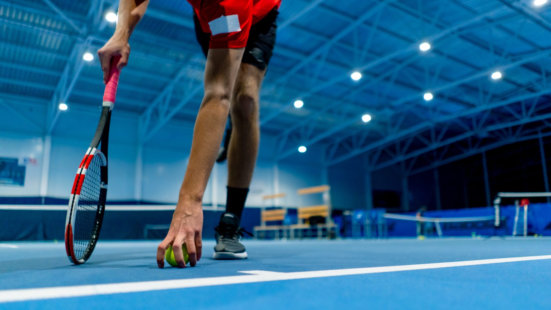 professional player coach standing in indoor tennis court front background small ball big sport training