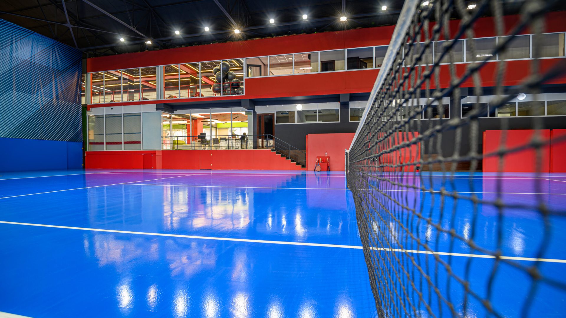 Blue colored indoor tennis court with nobody in it